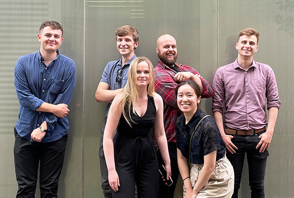 6 people standing in front of a wall