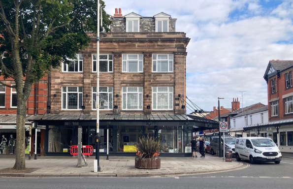 Traditional Victorian corner building in Southport, with a glass fronted shop facade on the ground floor.