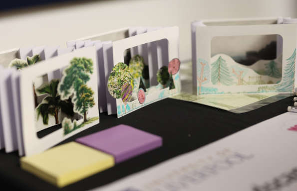 Three small accordion like paper sculptures depicting the structure and depth of forests.