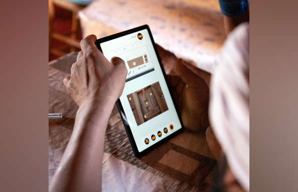 Photograph of a tablet being held in the hand with the outline of the users head.