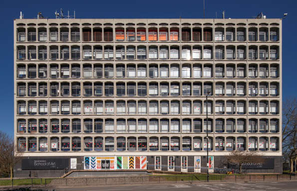 9 story Brutalist building photographed on a sunny day.
