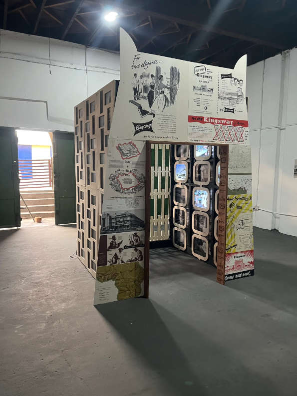 Internal pavilion structure with posters and period advertisements form the history of a Nigerian supermarket.