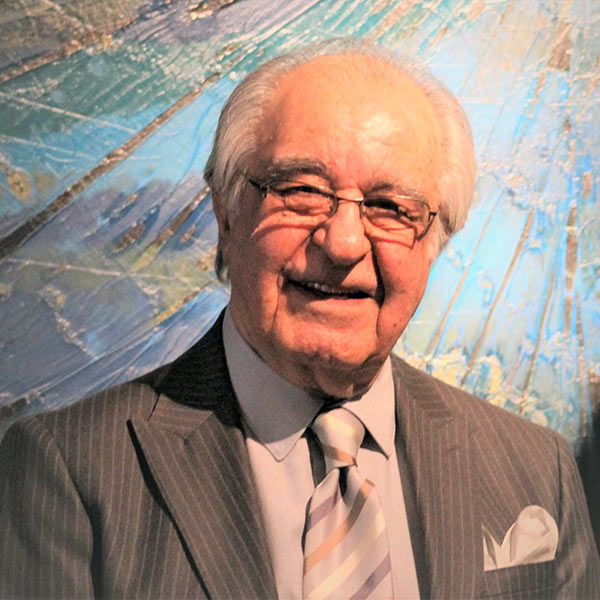 Elderly man wearing grey suit and striped tie