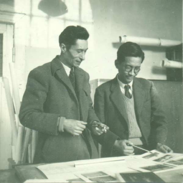 Two men standing next to each other and examining plans