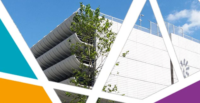 A brutalist building with layered concrete louvers on its facade and a tree in front.