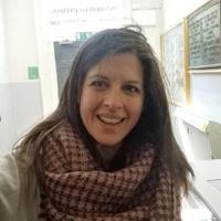 Smiling woman with shoulder length brown hair with a large scarf draped around her neck.