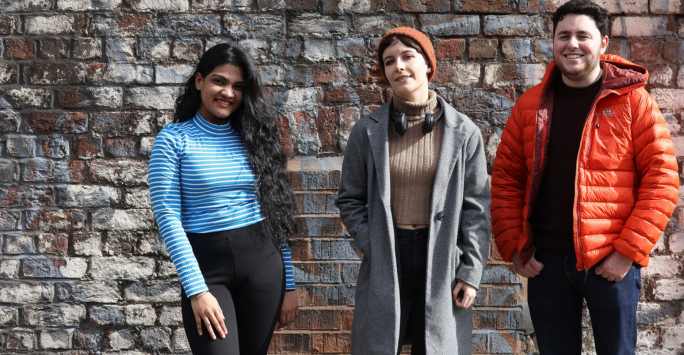 students in front of red brick wall