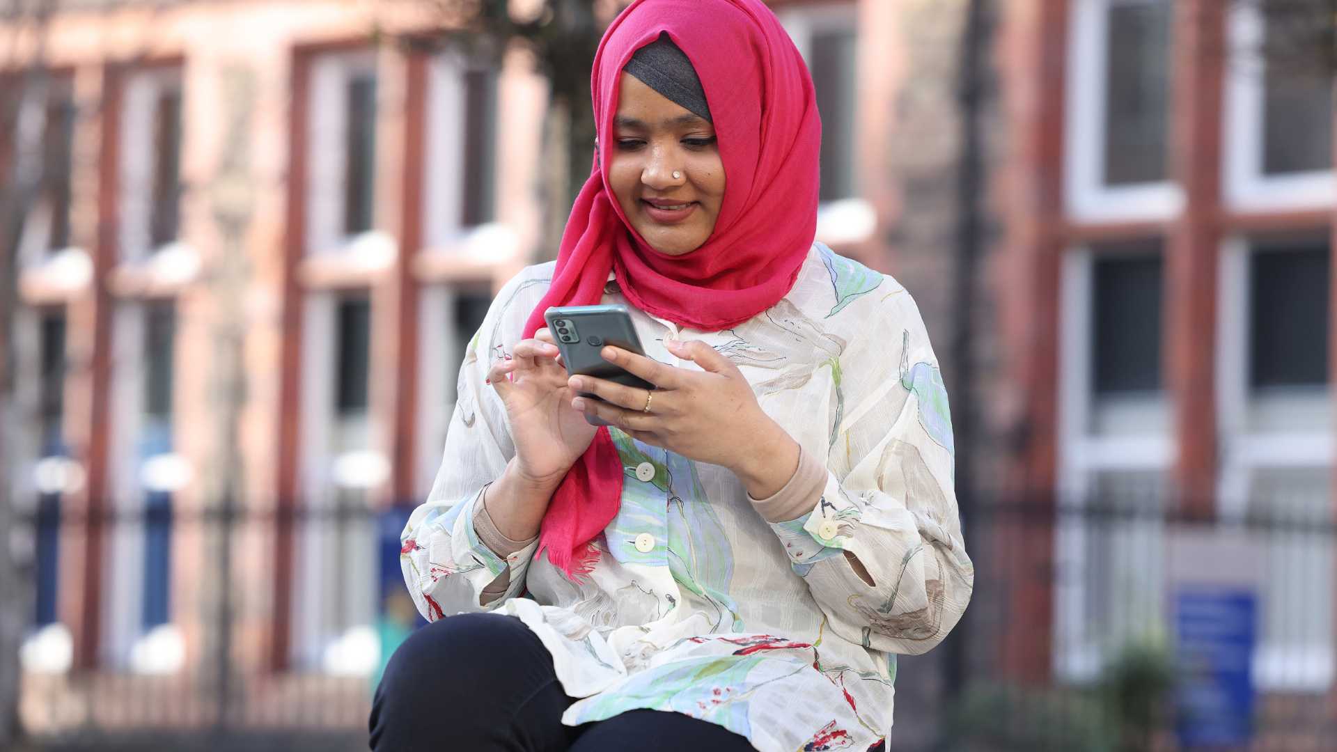 A student looking at her phone smiling