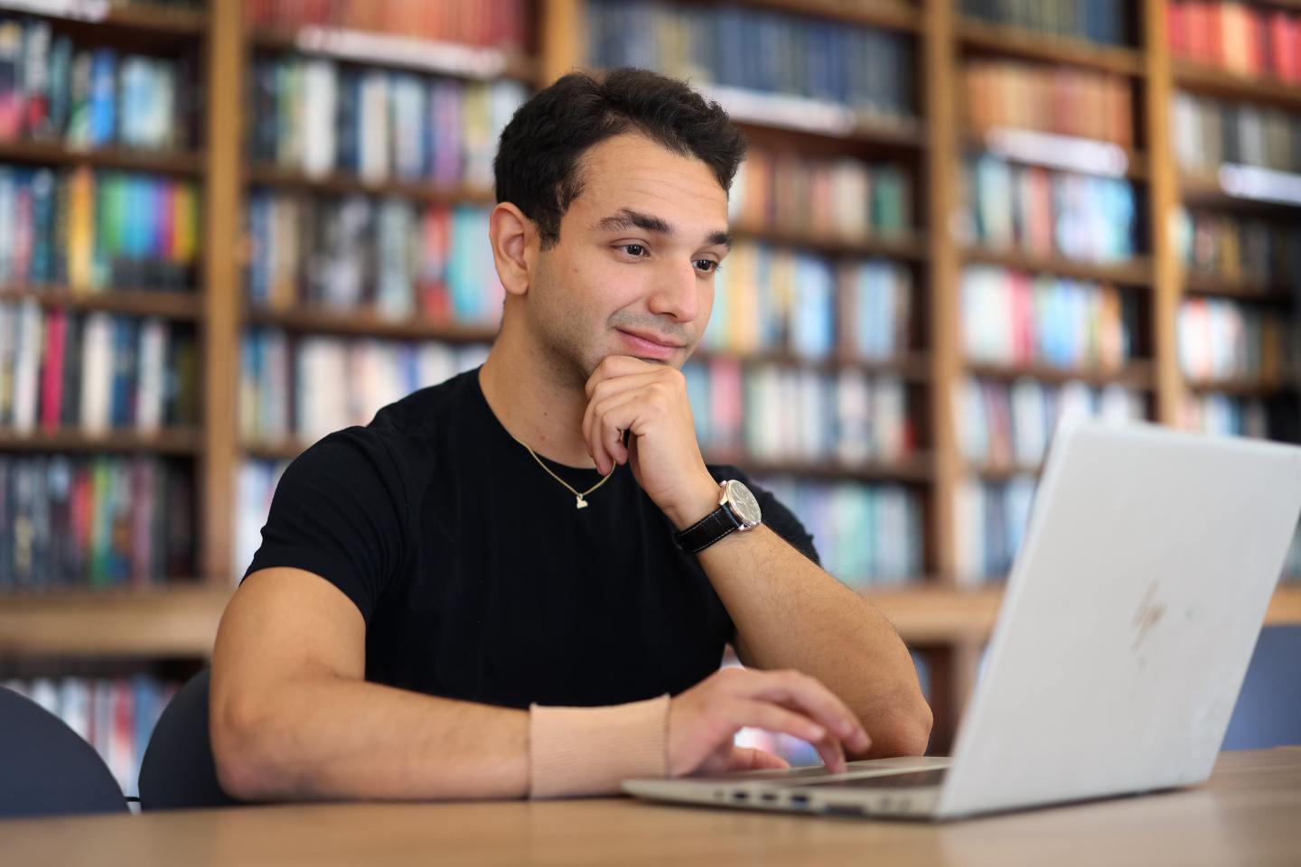 Student looking at his laptop at library
