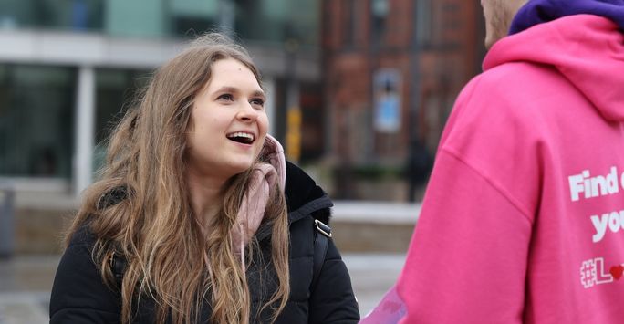 Student talking to another student volunteering in love Liverpool