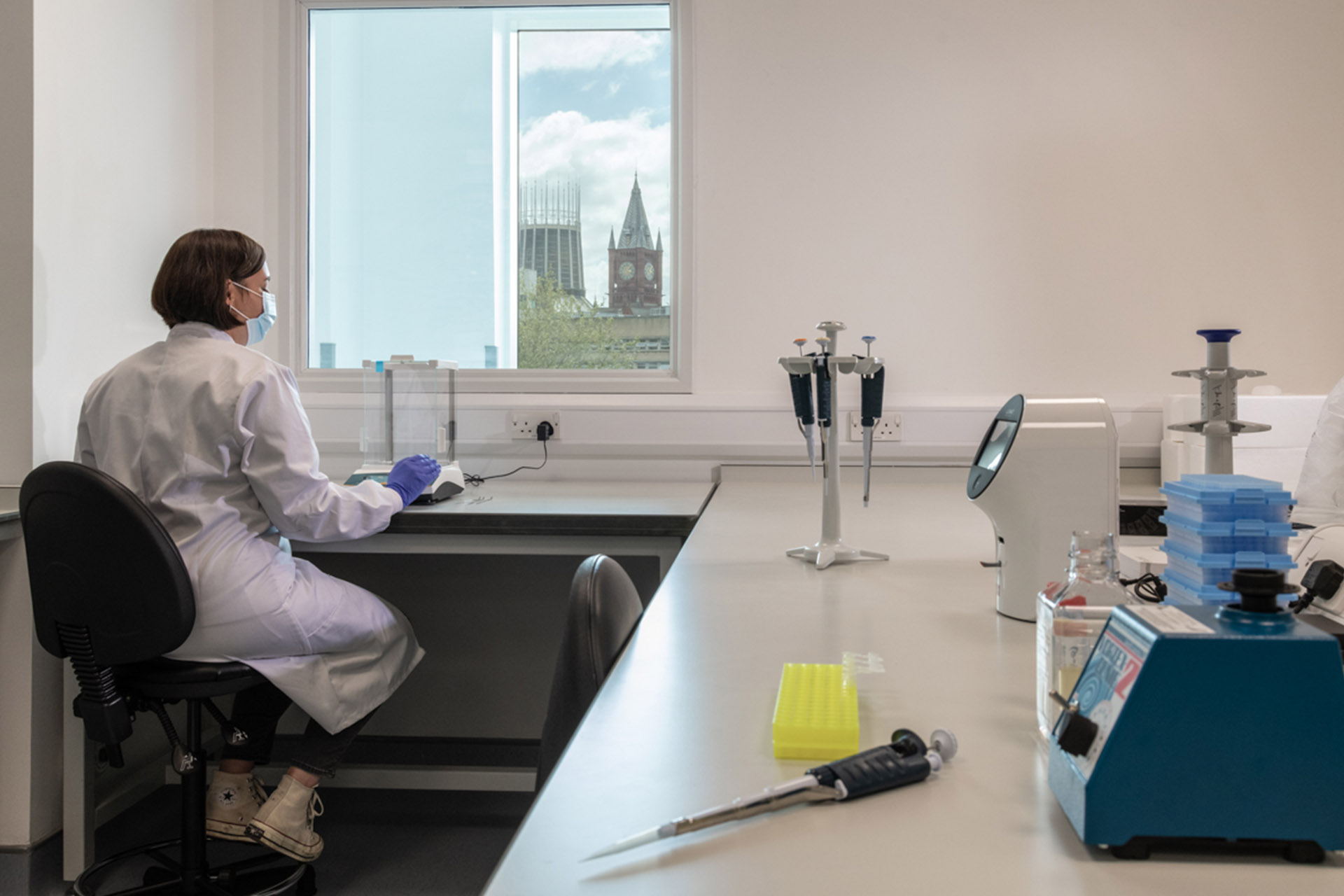 Female scientist sitting in a lab using equipment