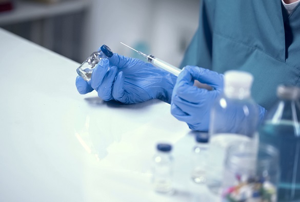 A syringe is being filled from a vial.