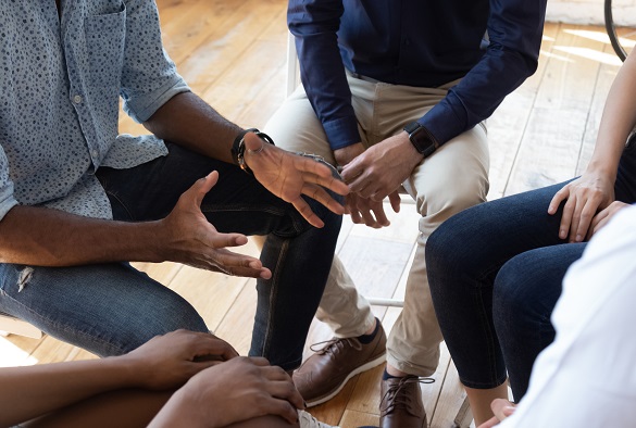 A community group are sat in a close circle for a discussion