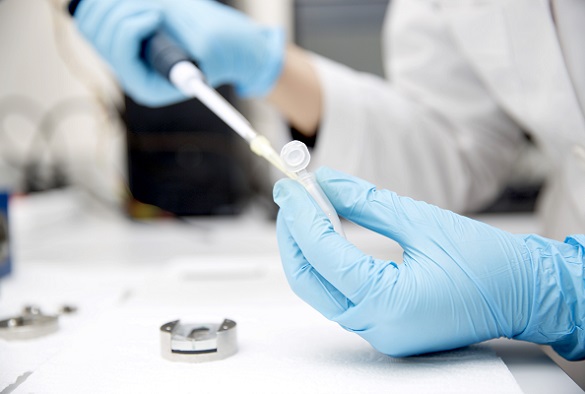 A scientist is using a pipette at their workbench