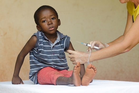 A child is being prepared for an injection in their arm
