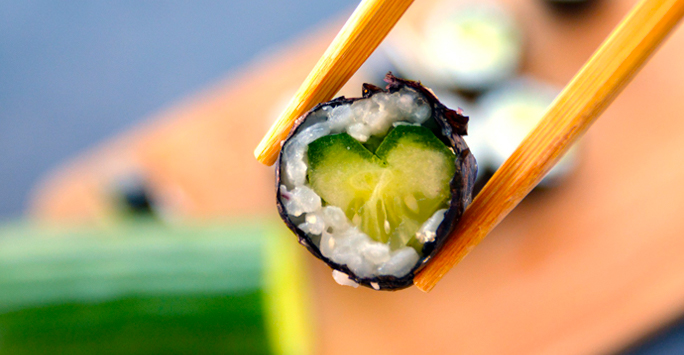 Chopstick picking up sushi roll