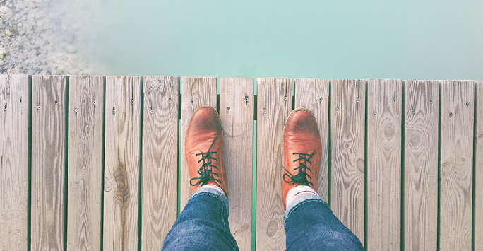 Man standing on the edge of a wooden bridge