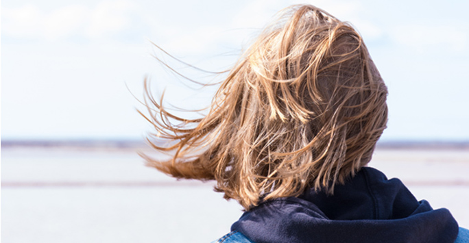 Wind blowing persons hair on beach