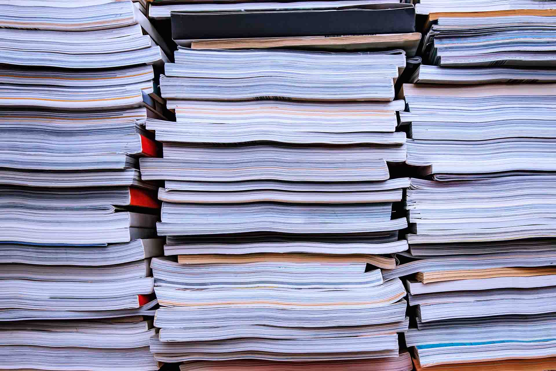 A close-up photograph of stacks of academic publications