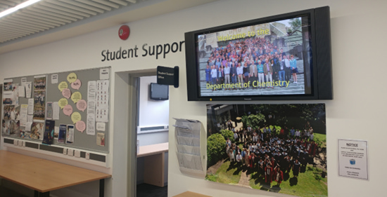 A large television mounted on the wall in a classroom, designed for educational presentations and student engagement.