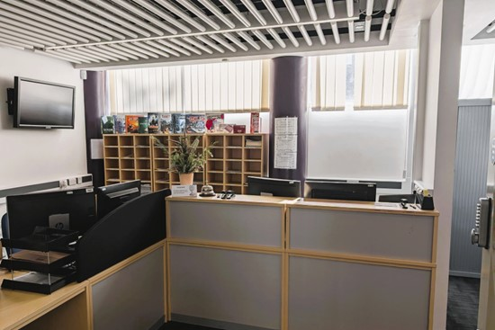 A reception area featuring a desk and a television, designed for welcoming visitors and providing information.