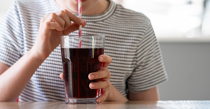 Child drinking fizzy drink through a straw