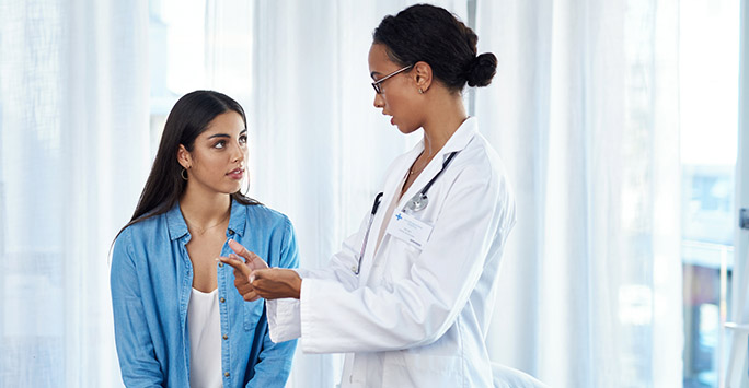 Female doctor talking to a female patient in a hospital