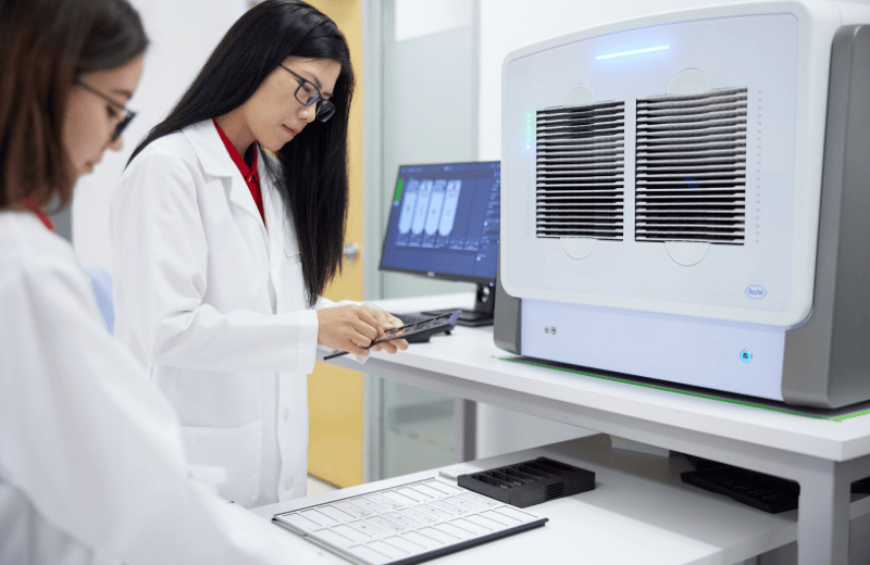 Two scientist are using a piece of equipment in a lab