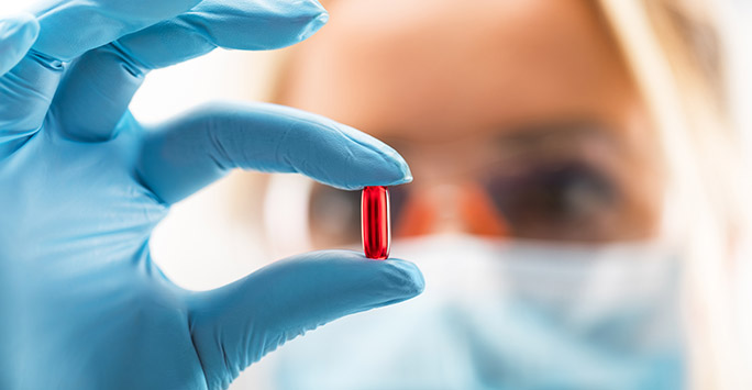 Lab scientists looking at a medicine tablet