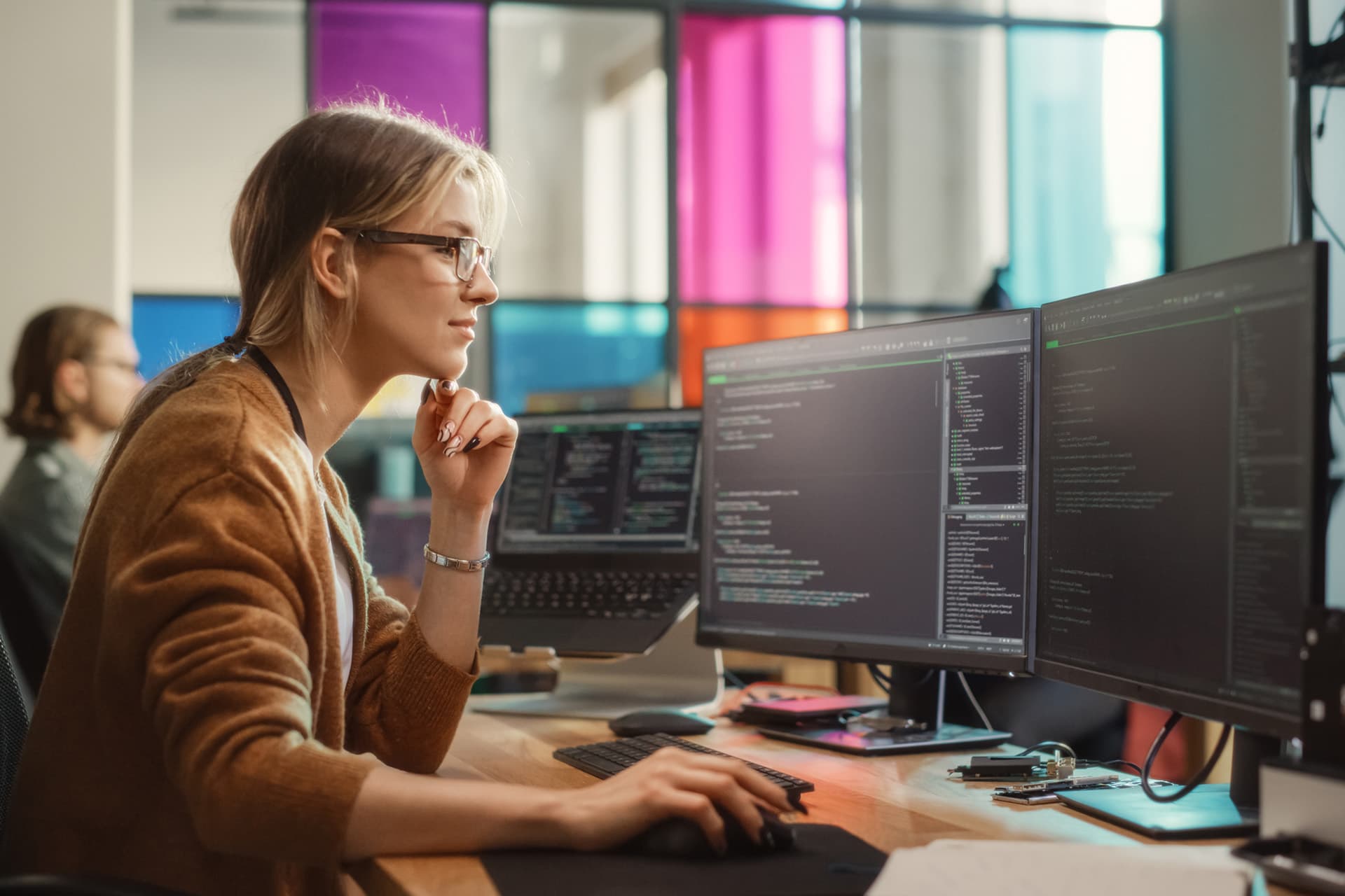 Woman working at multiple computer monitors