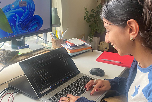 A member of IT staff sat working at her desk at home