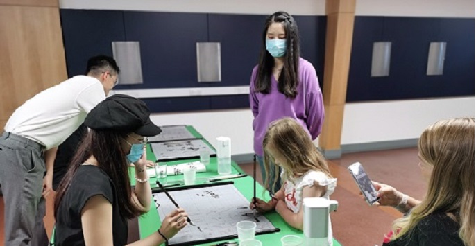 Confucius Institute teachers Ruolin Zhen and Ziwei Gou teaching Chinese Calligraphy to the public