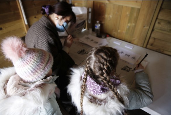 Two children learning Chinese calligraphy