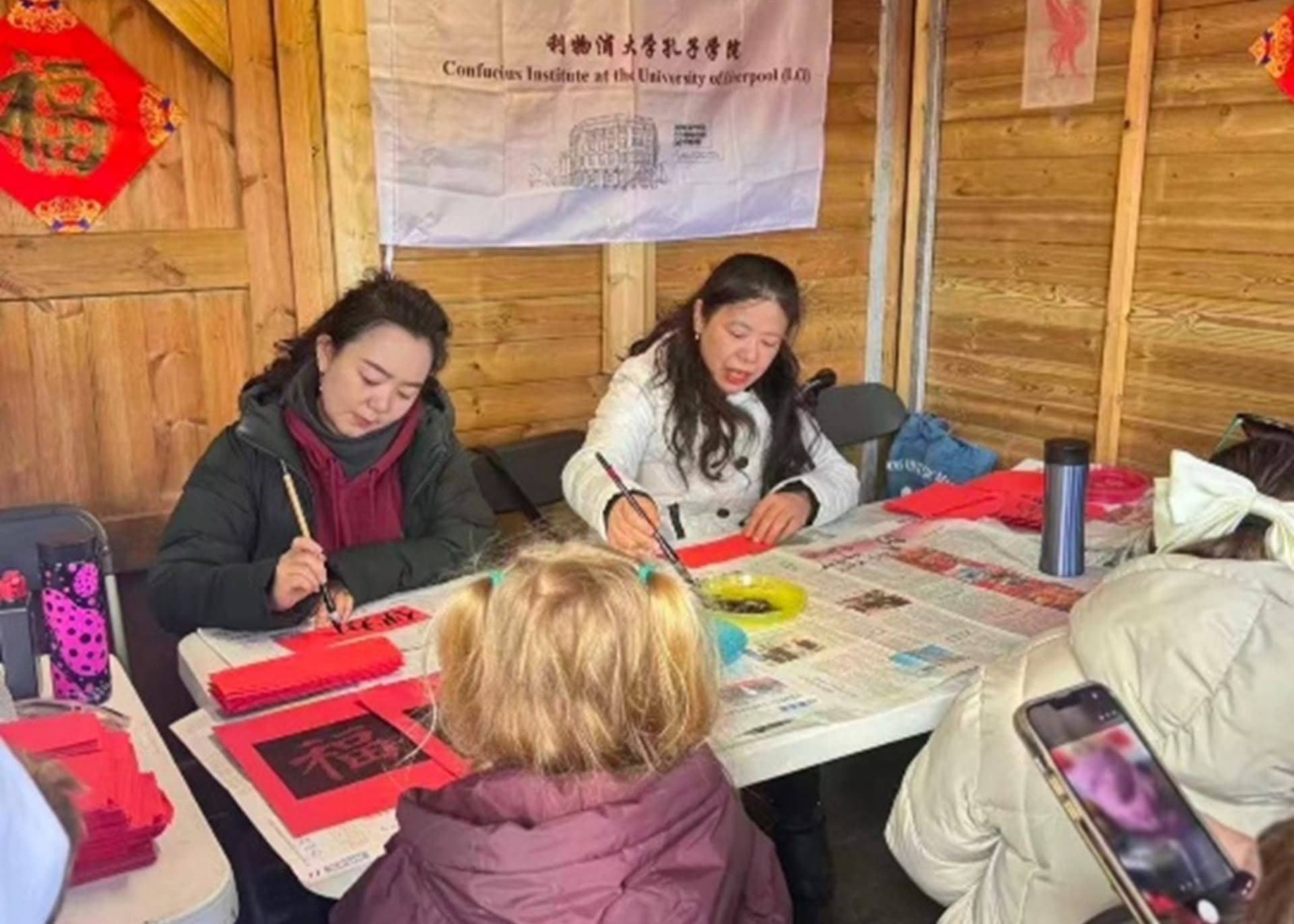 LCI team sat in a chalet in Chinatown, writing people's names in mandarin characters.