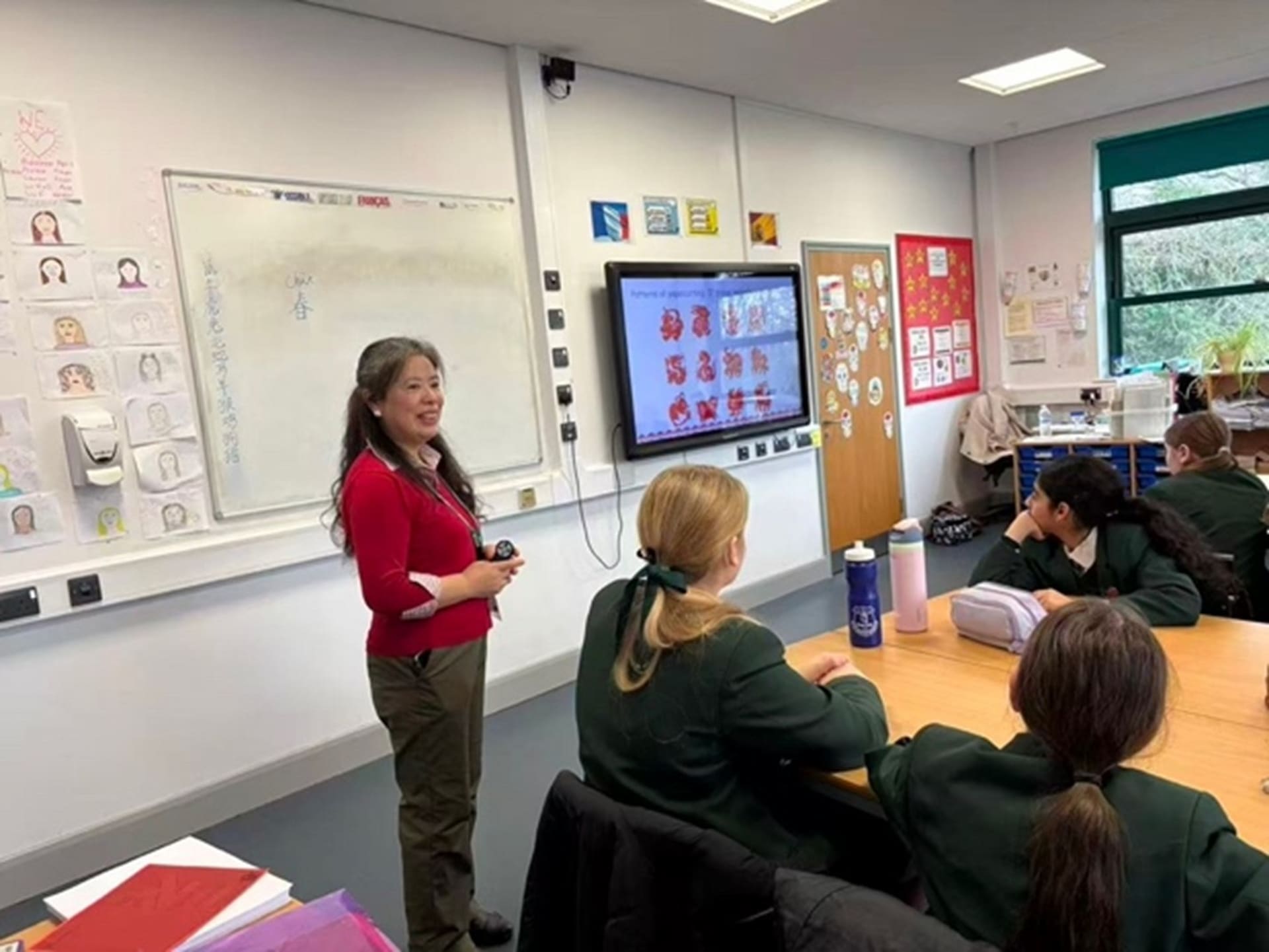 A LCI tutor in a school classroom, teaching pupils about Chinese New Year.