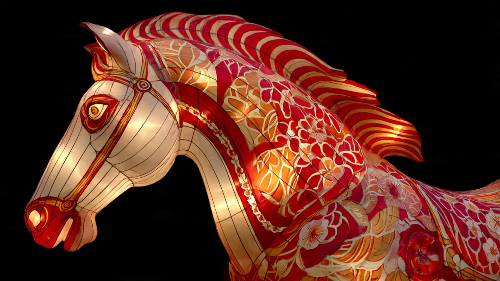 A gold and red lantern in the shape of a horse.
