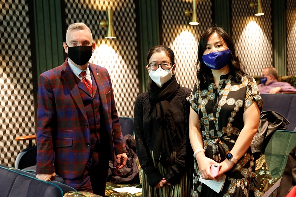 a man and two women stand with masks on