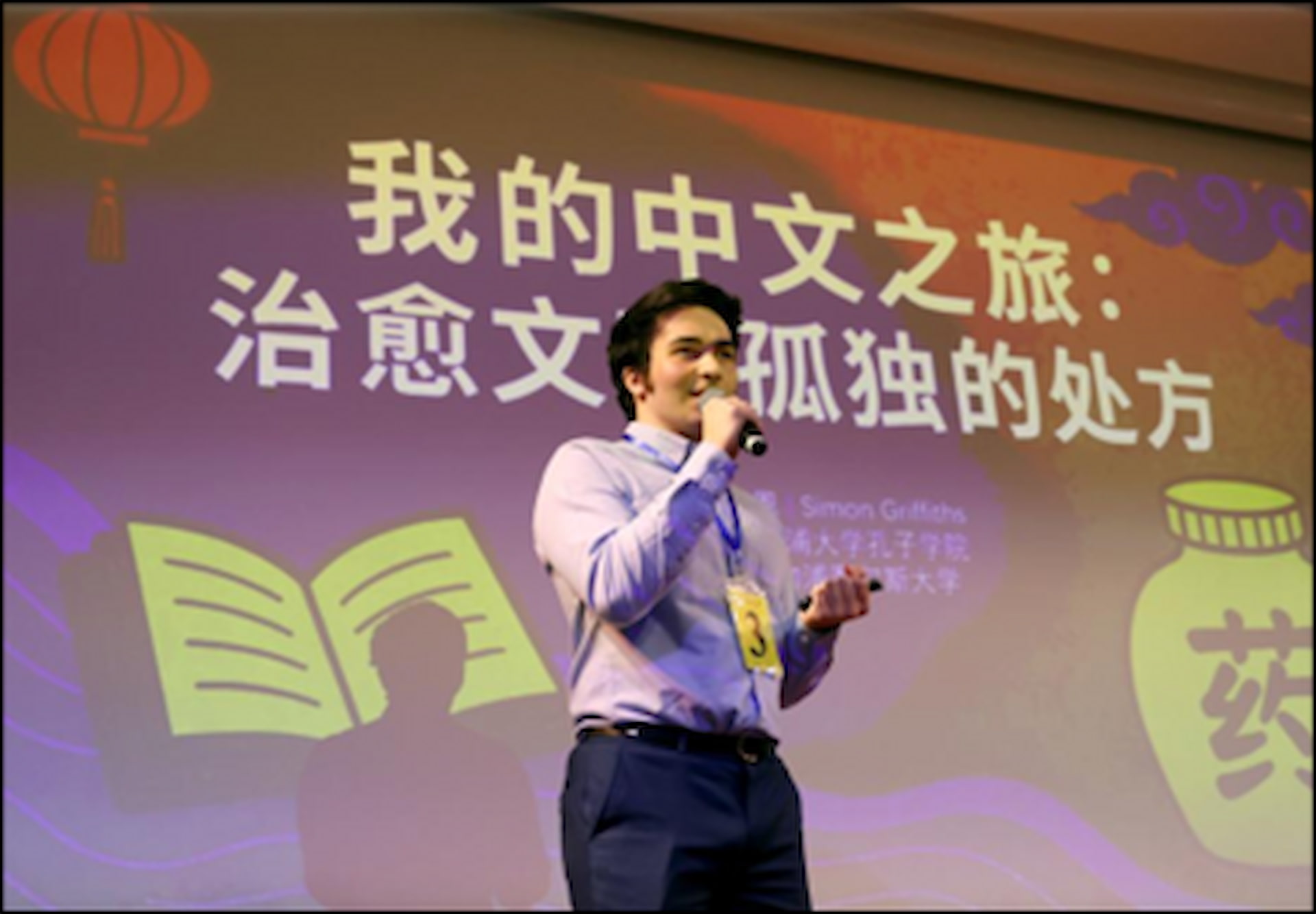 Simon Oliver Griffiths speaking into a microphone at the the 24th “Chinese Bridge” Chinese Proficiency Competition UK Regional Final