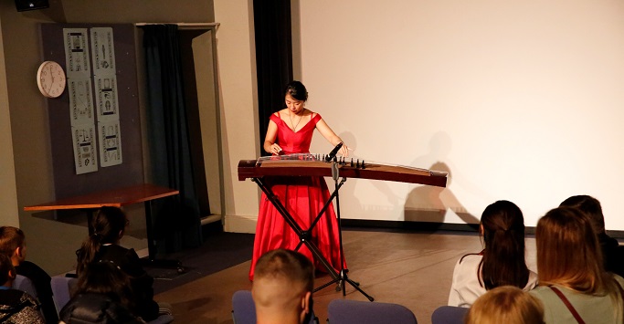 Confucius Institute teacher Xiaoxiao Hou playing traditional Chinese Guzheng musical instrument