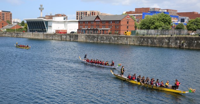 three dragon boats racing in Liverpool Docks