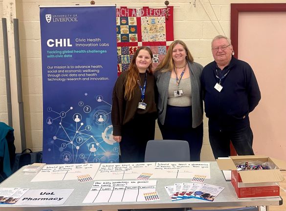 Three people standing at an exhibition stand