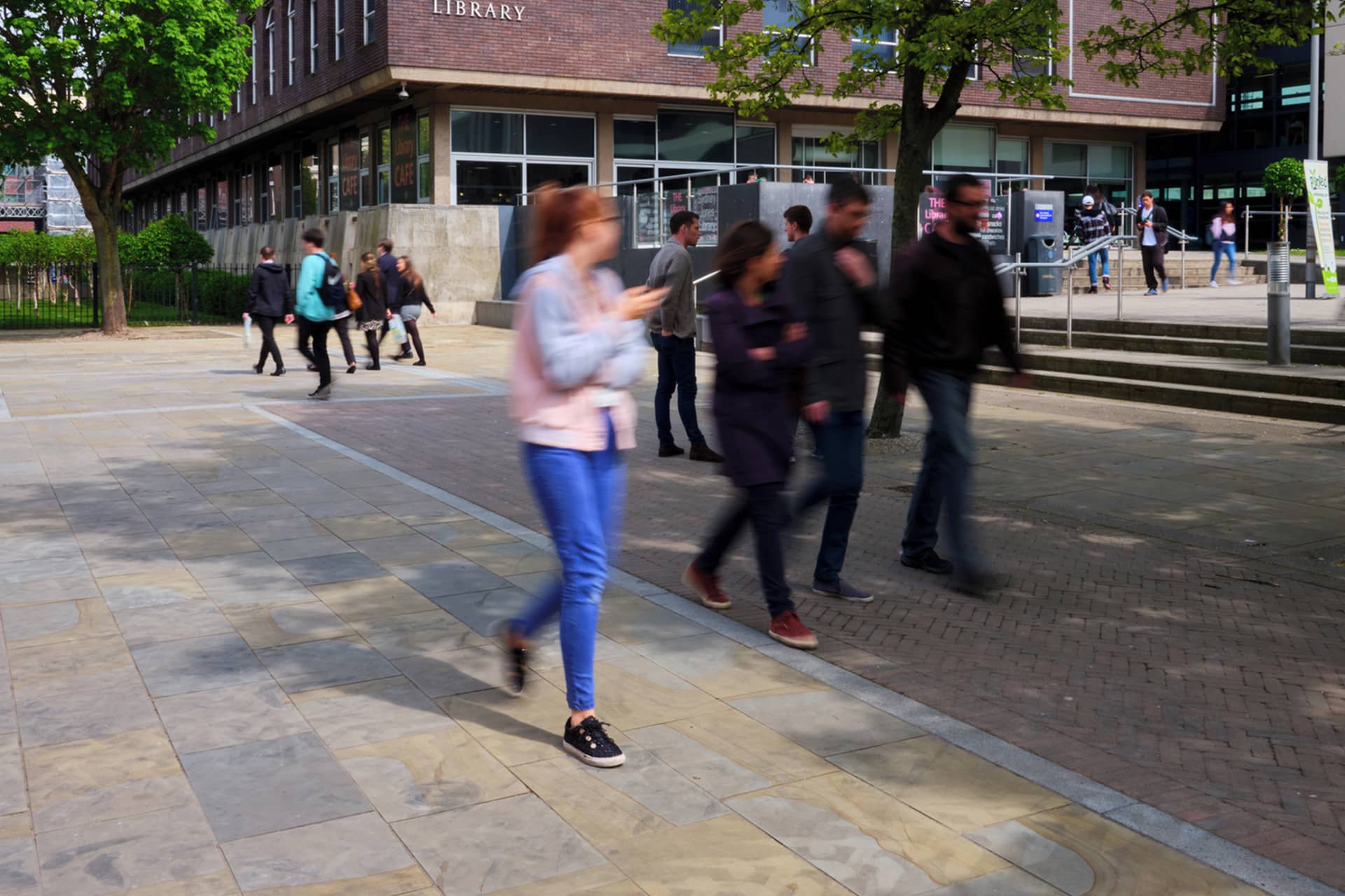 group of students walking past the library