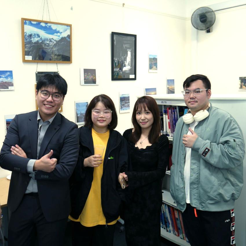 4 PSE students smile at the camera during a social event in the Language Lounge