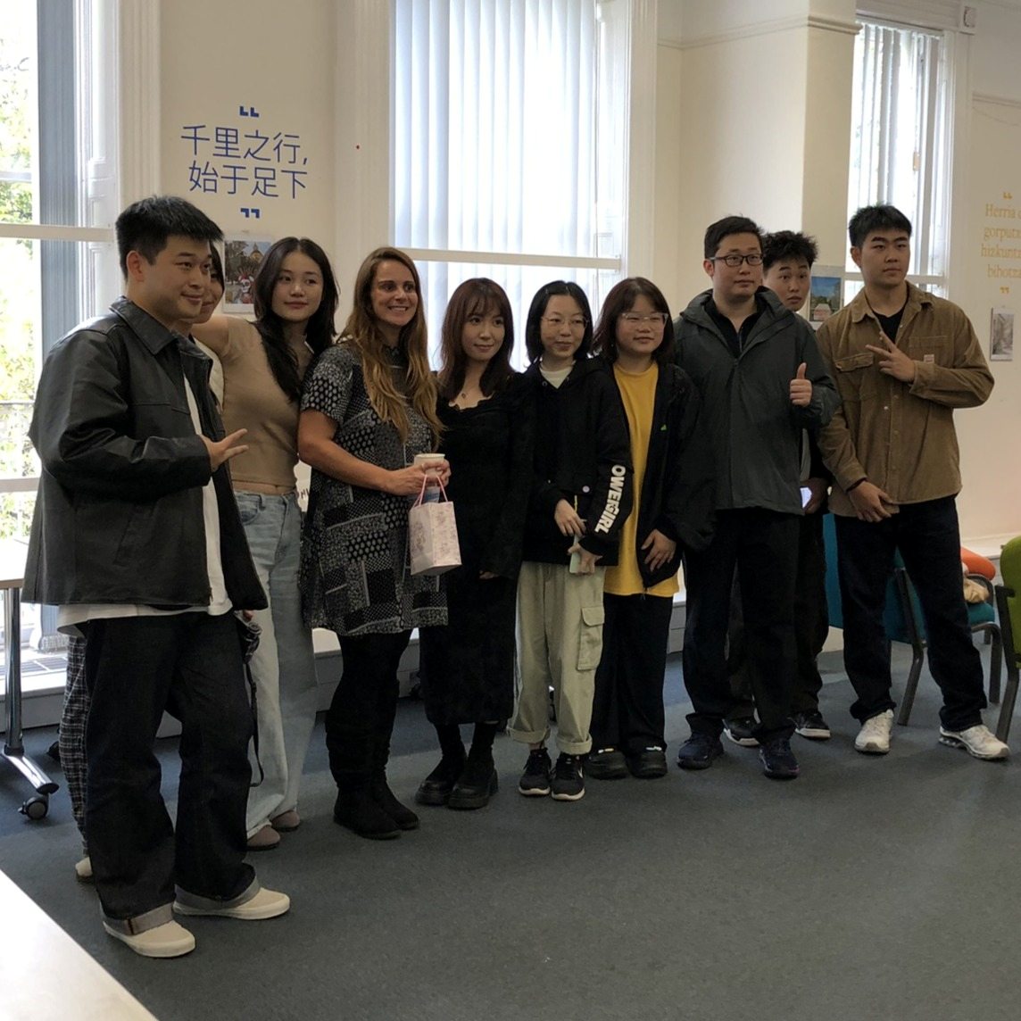A group of students and a teacher pose for a photo in the Language Lounge