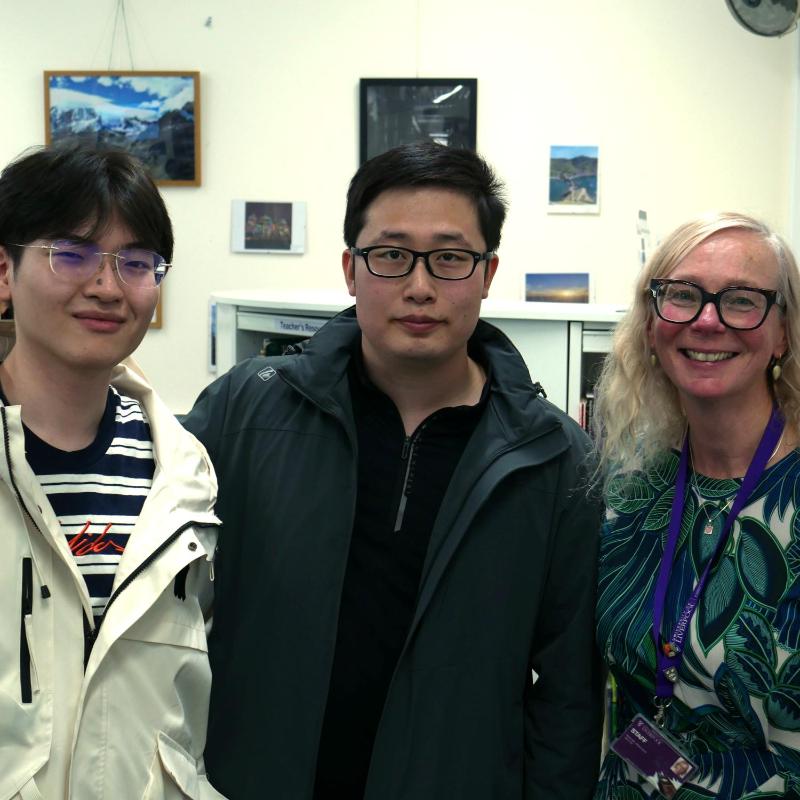 Two PSE students and a teacher pose for a photo in the Language Lounge
