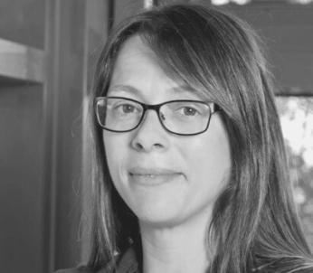 Greyscale portrait of white female with long brown hair wearing glasses