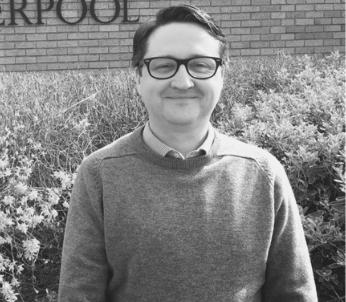 Greysale photo of white male with short brown hair wearing glasses