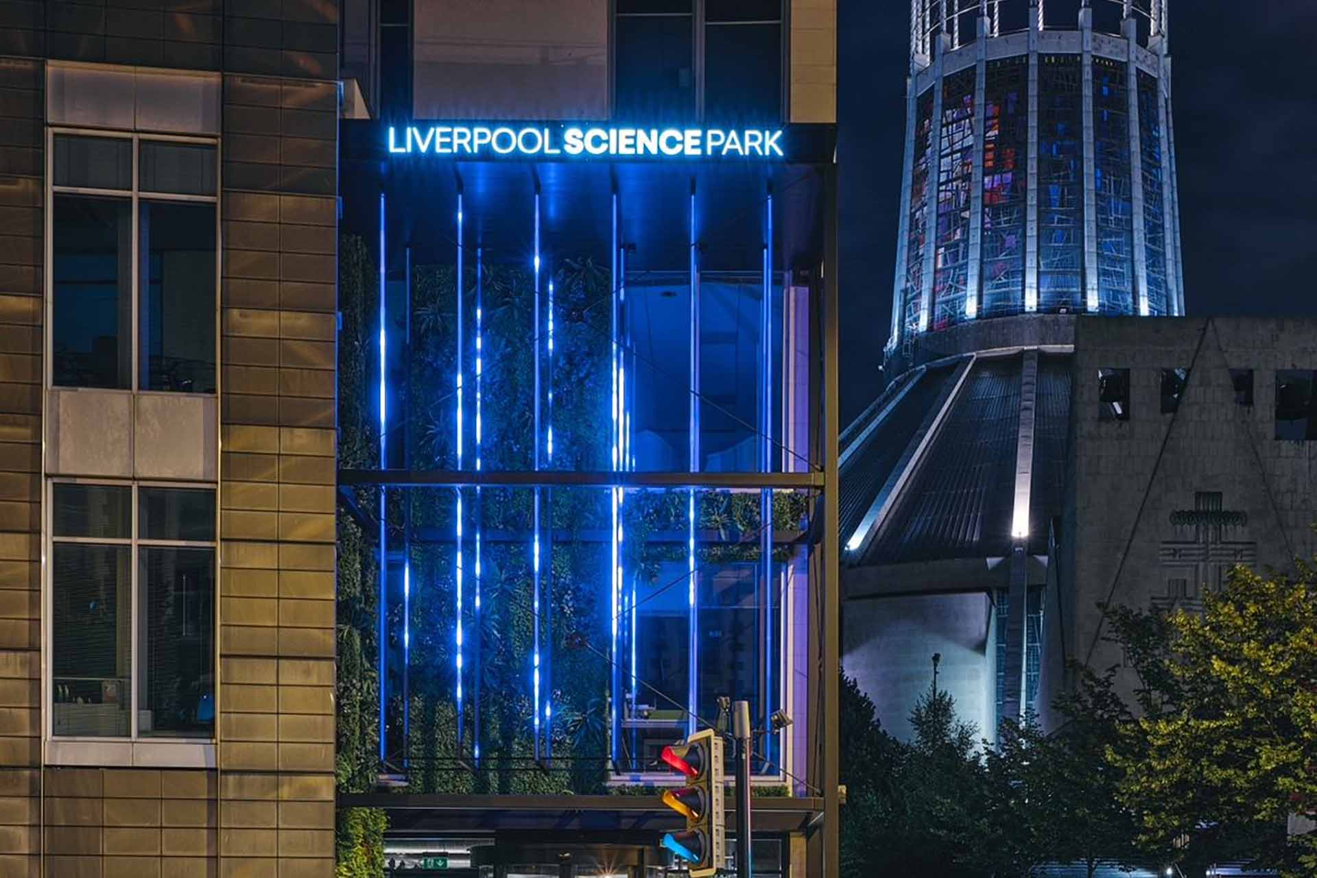 Exterior shot of the front of the Liverpool Science park building with Liverpool Metropolitan Cathedral in the background.
