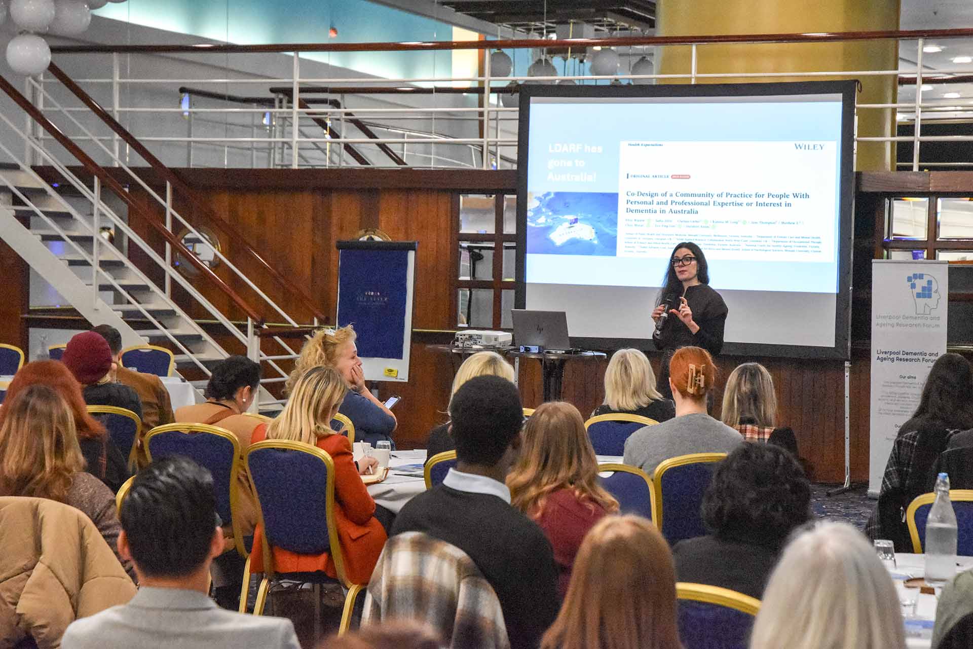 Delegates attend the Annual Dementia Conference, watching the speaker at a podium