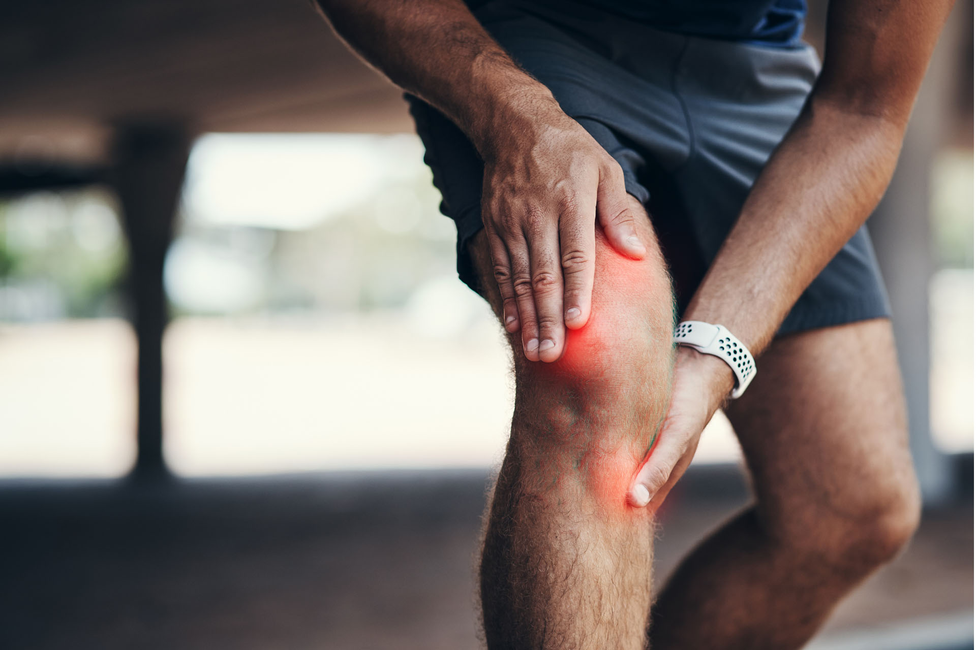image of person holding a knee coloured red to indicate pain